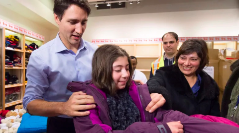 Justin Trudeau handing out winter coats to Syrian refugees
